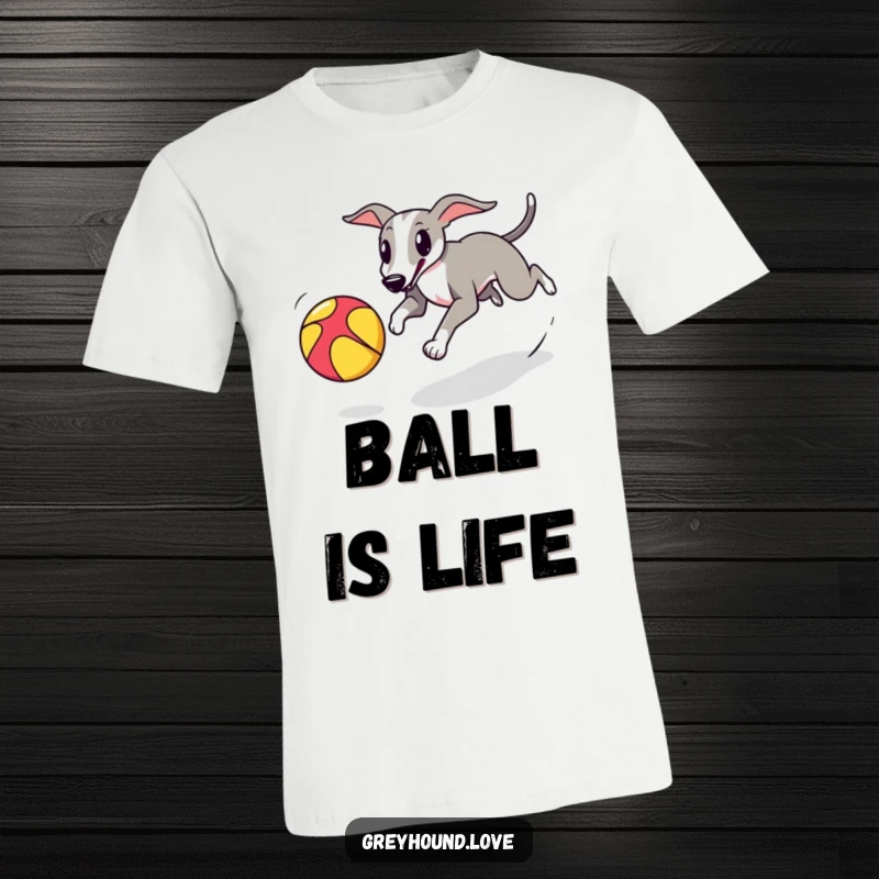 A greyhound playfully chasing a colorful bouncing ball is depicted on a comfortable t-shirt for dog enthusiasts.