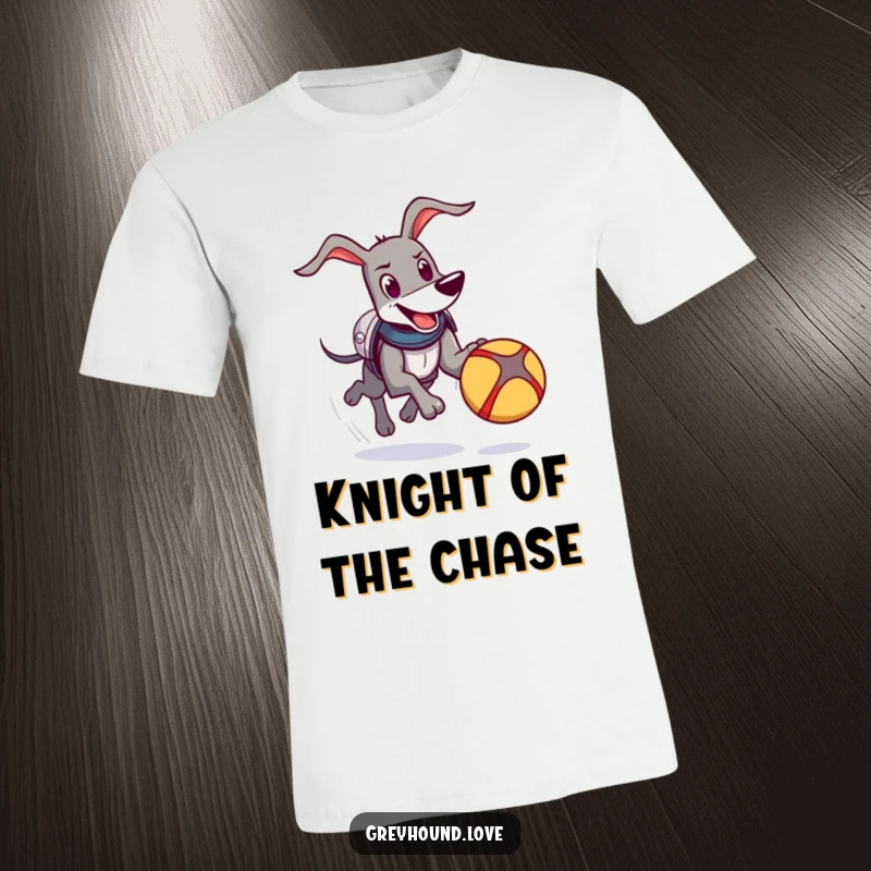 Funny Knight Greyhound T-Shirt: A happy greyhound wearing comical armor energetically chases a bouncing ball with pure delight.